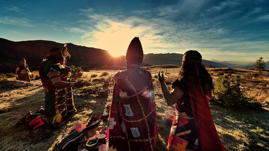 people in brown and red robe standing on brown sand during daytime