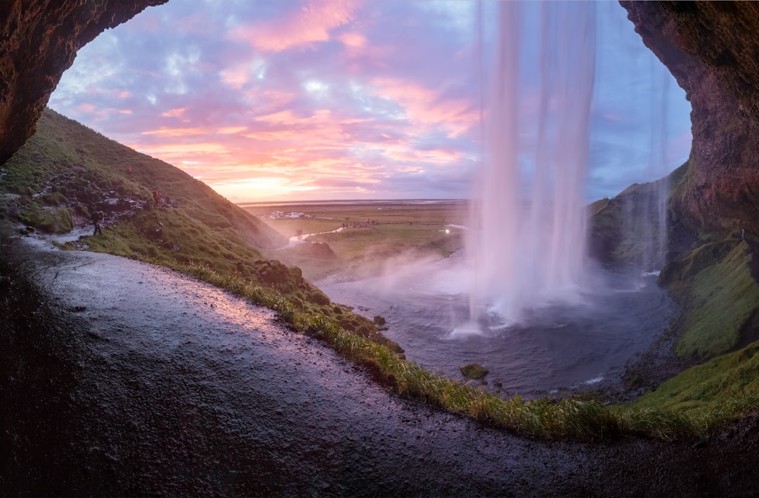 Chute de Seljalandsfoss en Islande, cascade encaissée dans un paysage volcanique verdoyant