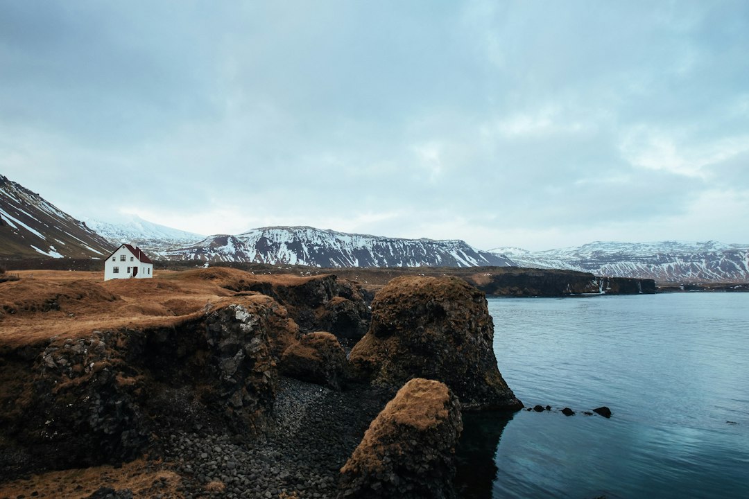 Maison isolée blanche et bleue sur une falaise au bord de la mer, dans les Vestfirðir en Islande