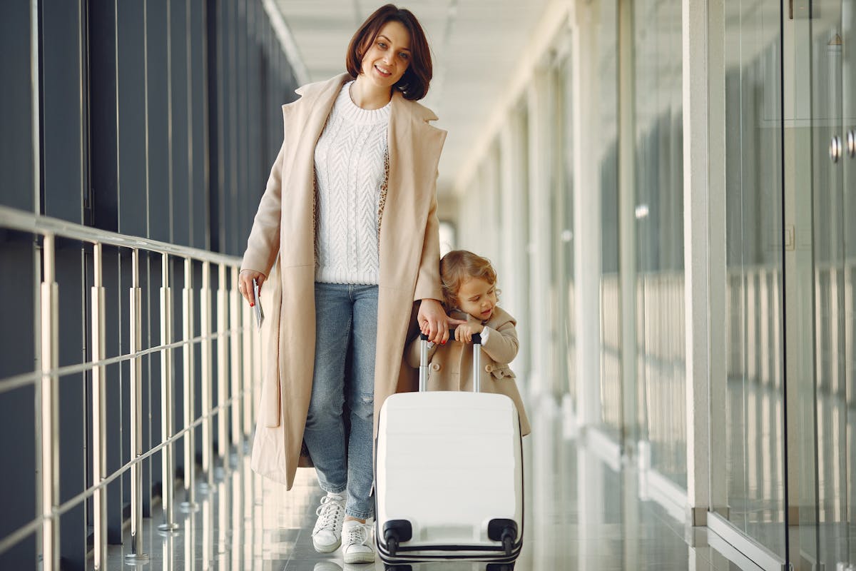 Mère et fille avec valise dans un couloir d'aéroport - voyage maman solo