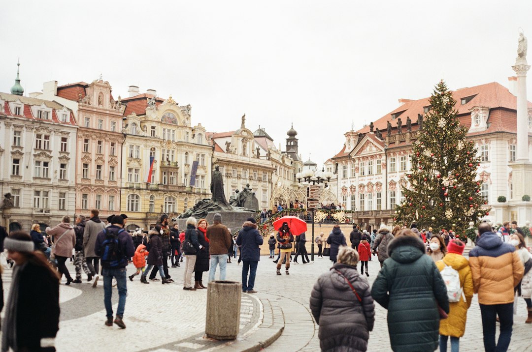 Passants sur la place de la Vieille-Ville de Prague, avec les façades historiques en arrière-plan