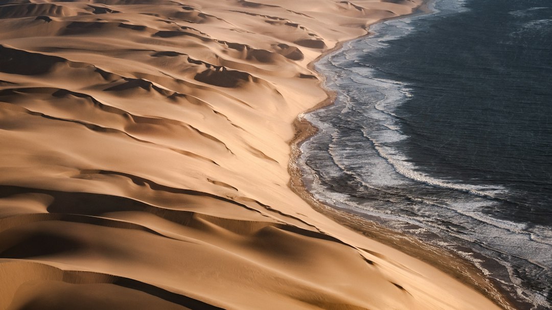 Dunes du désert du Namib en Namibie, à l'endroit où le sable rejoint l'océan Atlantique