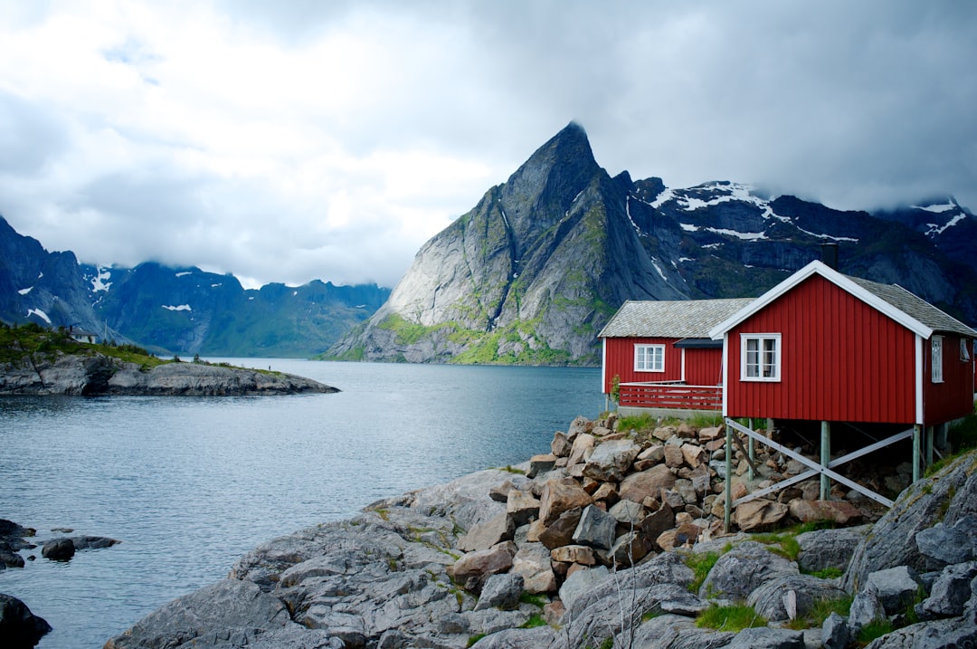 Village de pêcheurs de Reine, dans les îles Lofoten en Norvège, maisons rouges typiques au bord du fjord