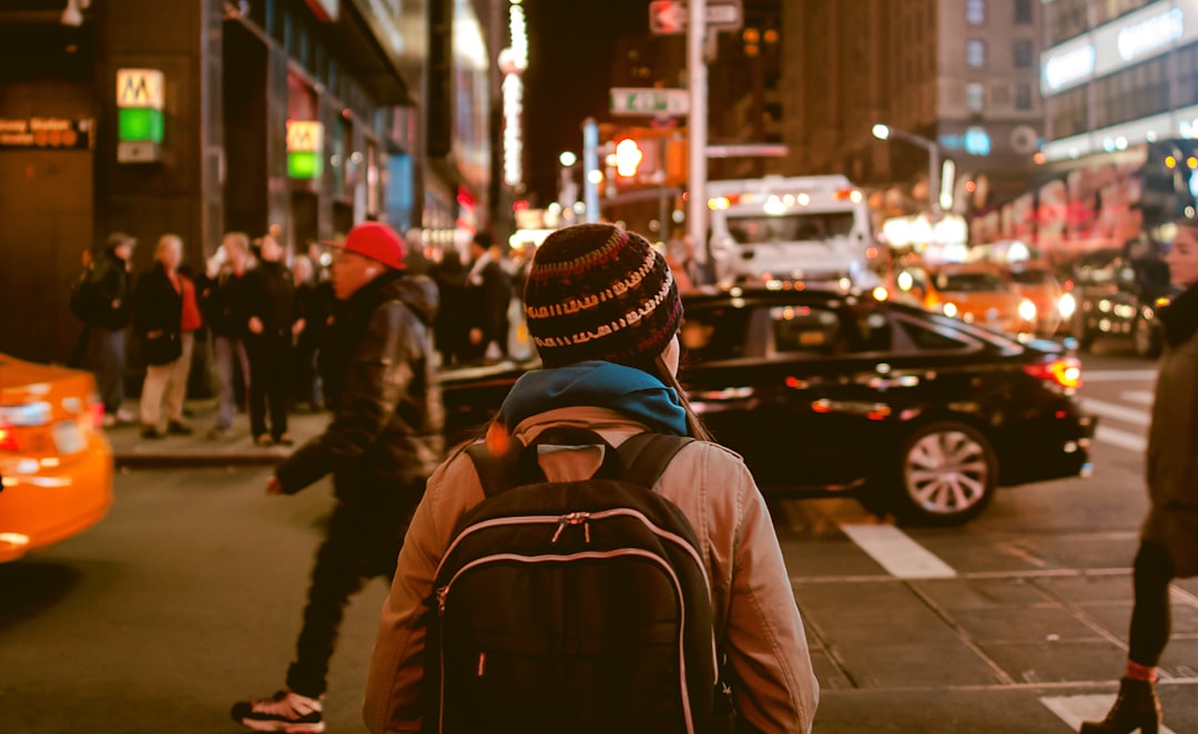 Un voyageur seul traversant une rue animée à New York, reflet de la liberté urbaine du voyage solo