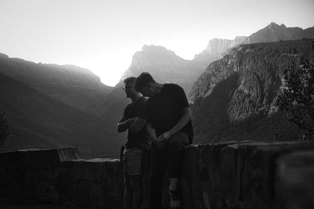 Two men looking at a mountain landscape at sunset