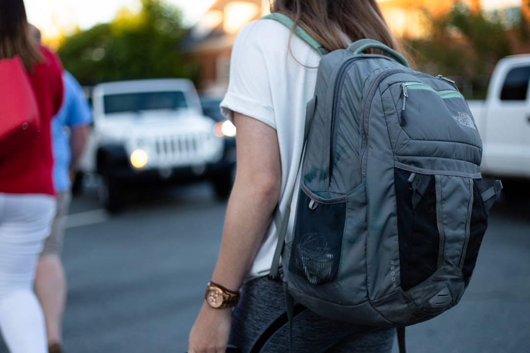 Voyageuse solo avec sac à dos gris en milieu urbain, illustrant la sécurité en déplacement indépendant