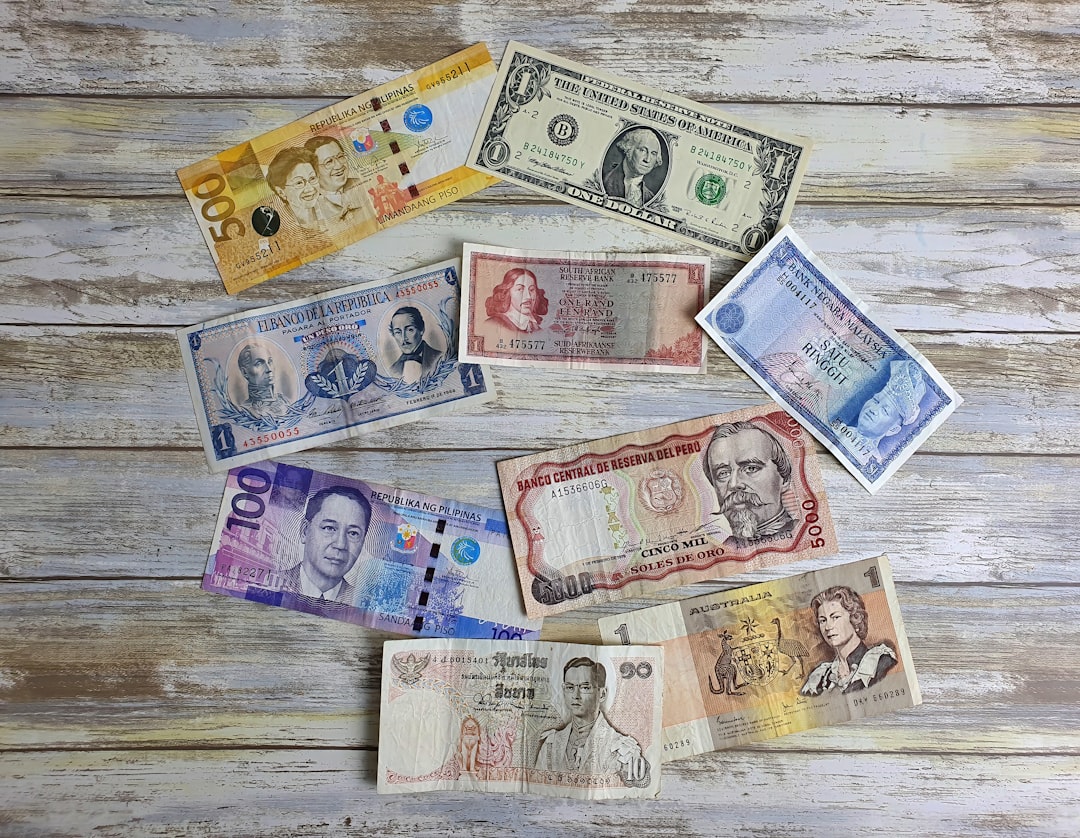Billets et pièces de différentes devises étalés, illustrant le change d'argent en voyage