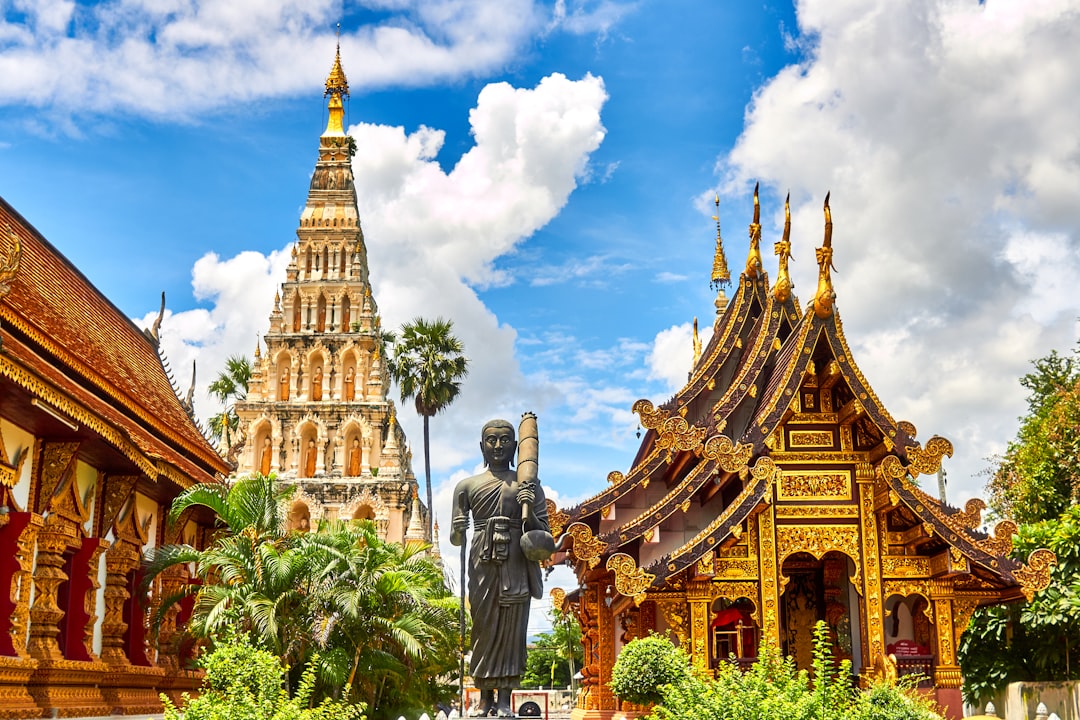 Temples bouddhistes sculptés dans le nord de la Thaïlande, vus depuis une route de montagne à moto