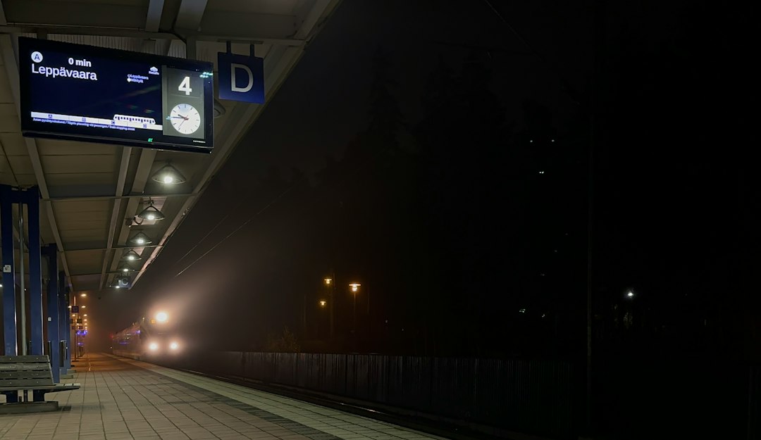 Gare ferroviaire la nuit, quais éclairés en attente d'un train de nuit