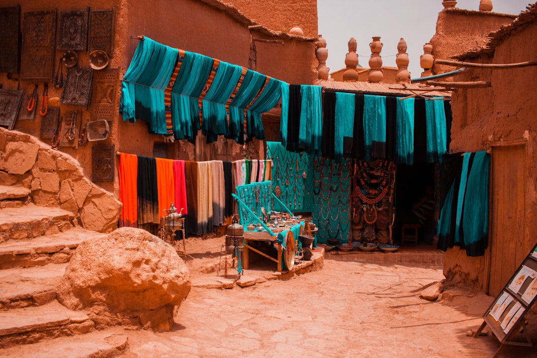 Tissus colorés accrochés dans les ruelles d'une médina marocaine, atmosphère de souk en automne