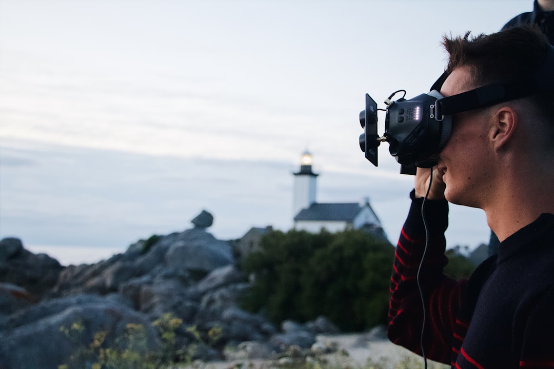 woman in red and black jacket holding black dslr camera